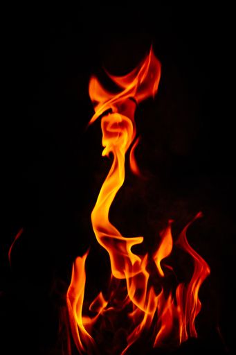 A vertical shot of beautiful burning flames at night
