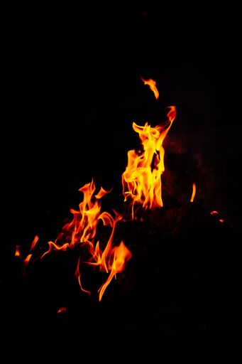 A vertical shot of beautiful burning flames at night