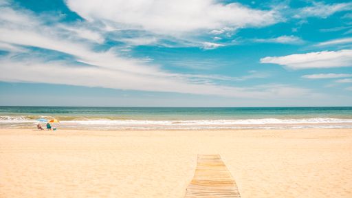 A beautiful view of the ocean and the sandy beach under the cloudy sky captured in Andalucia, Spain