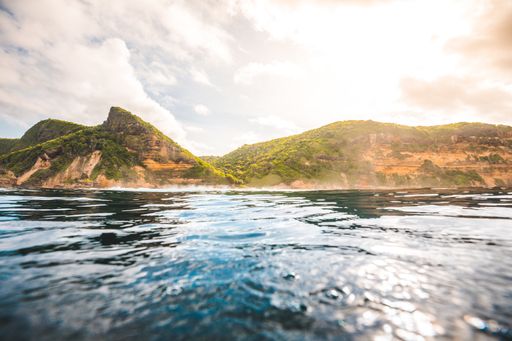 A breathtaking view of the ocean and cliffs covered with plants captured in Lombok, Indonesia
