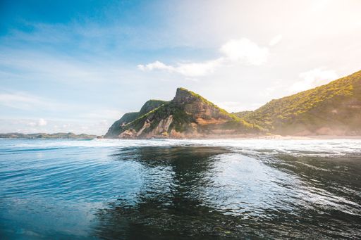 A magnificent view of the green cliffs and the shore captured in Lombok, Indonesia