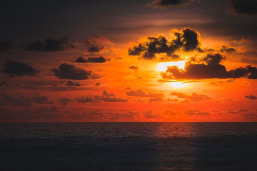 A beautiful view of the ocean and the sunset behind the clouds captured in Bali