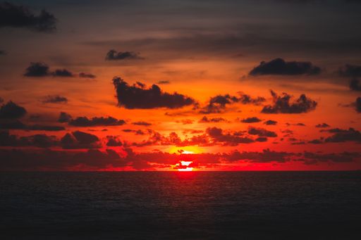 A beautiful view of the ocean and the sunset behind the clouds captured in Bali
