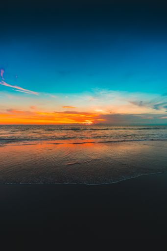 A vertical shot of the ocean at the beach under the clear blue sky captured in Bali