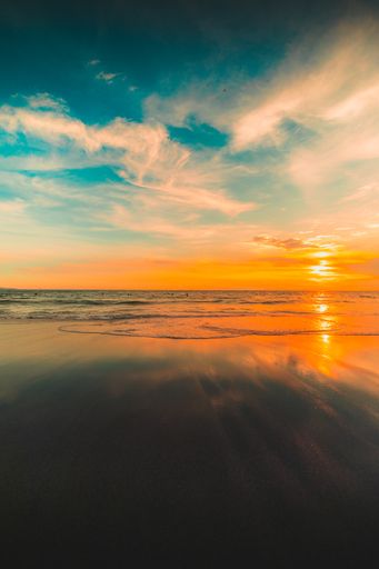 A vertical shot of the reflection of the sunset in the beautiful sky over the sea captured in Bali