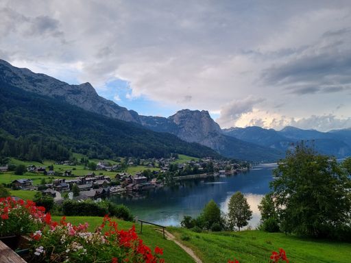 An aerial view of blooming fields and houses near the shore of Grundlsee, Austria