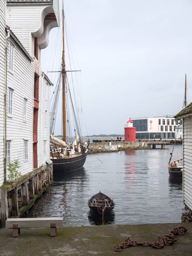 A vertical shot of boats on the river surface in Alesund, Norway