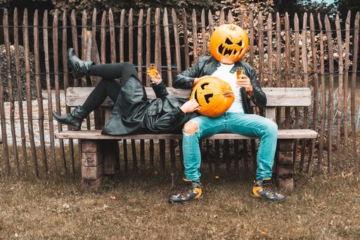 A view of couple wearing pumpkins on head