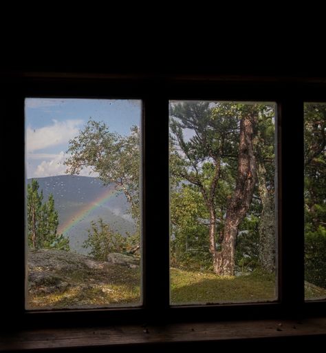 A beautiful view of a rainbow through a rained window with droplets