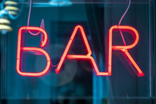 A closeup of a "BAR" logo with neon lights on the window