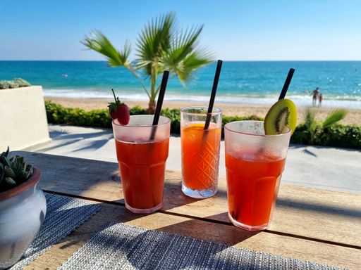 A closeup shot of iced fruity cocktails on a resort near the sea