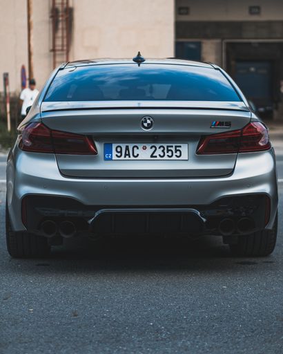 A vertical shot of a parked BMW M5 competition from the back
