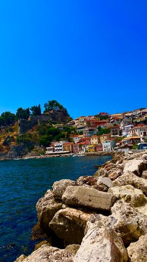 A vertical shot of a coastal cliff and a city by the seaside
