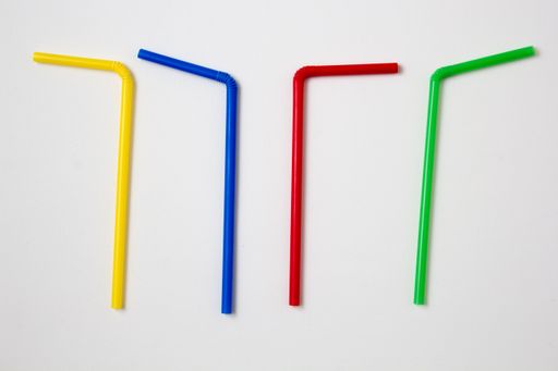 A flat lay of colorful bendy straws isolated on white background