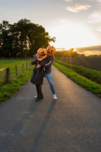 A view of couple wearing pumpkins on head