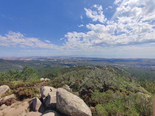 A scenic view of the green plains and hills under blue cloudy sky
