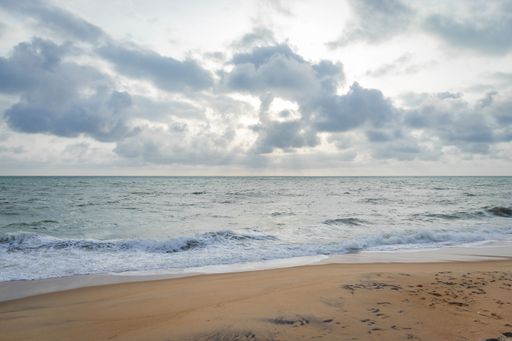 The calm waters of the Indian ocean and the sandy shore with the horizon in the background