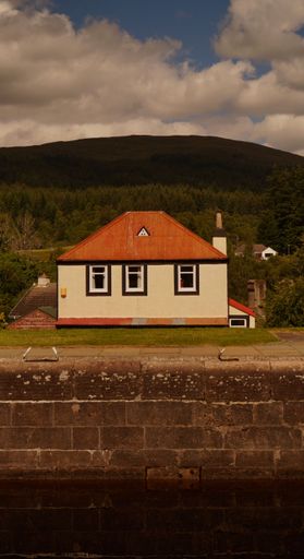 A vertical shot of a house with a green hill in the background. Edinburgh, Scotland, United Kingdom.