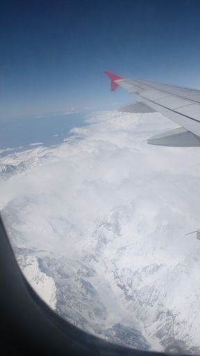 A vertical shot of a view od mountains from the airplane window