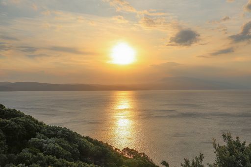 A high angle shot of the beautiful ocean with the reflection of the light of the rising sun