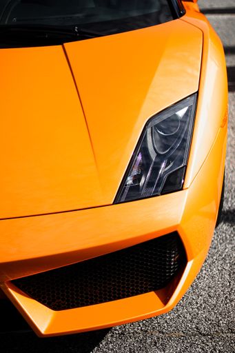 A vertical shot of the front of an orange luxurious Lamborghini Gallardo car