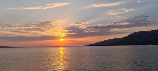 A scenic view of sea against the beach in Seline, Croatia at sunset