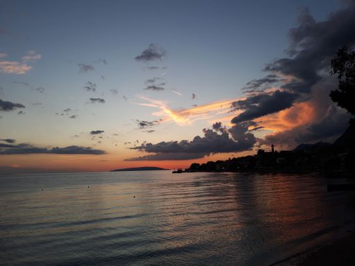 A beautiful shot of a sunset with a cloudy sky over a calm sea
