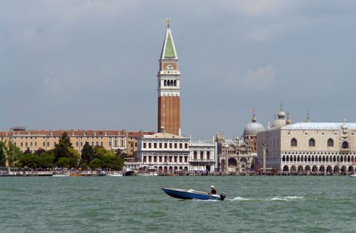 Boat passes through Saint Mark's Basin (Bacino San Marco). In background: Saint Mark's Square and Bell Tower, Saint Mark's Basilica and Doge's Palace.
