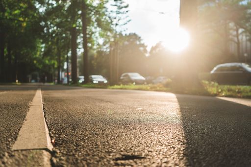 A closeup shot of the asphalt sidewalk gleaming under the sunrays
