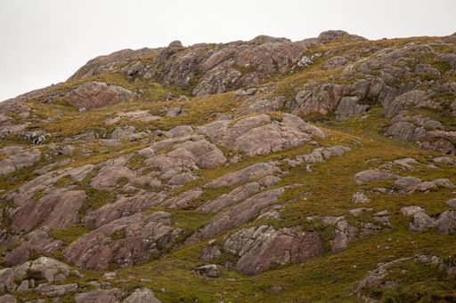 A big rocky cliff under the cloudy sky on a gloomy day during the daytime