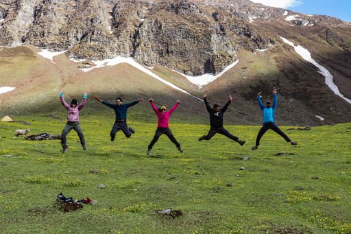 5 people jumping with joy with a mountains in background