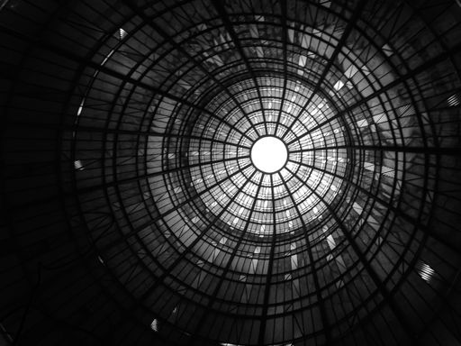 A low angle greyscale shot of an antique ceiling