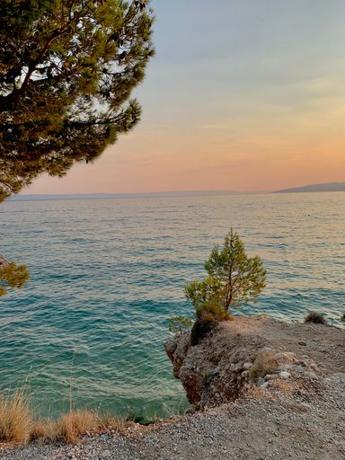 A vertical shot of a gorgeous colorful sunrise with a cloudy sky over a bright blue ocean
