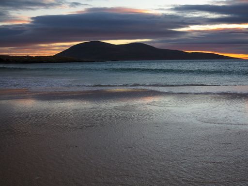A beautiful view from the beach of sea and mountain at sunset in Isle of Harris
