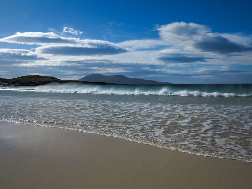 A beautiful shot from the beach of the sea waves and blue cloudy sky in Isle of Harris