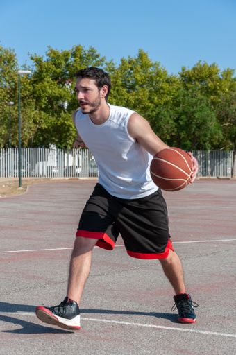 A male playing basketball in the fresh air