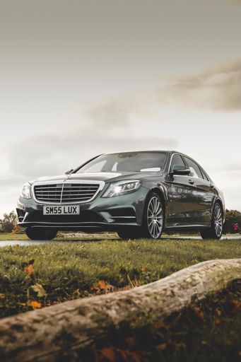 A black Mercedes Benz C-Class on a golf course against the sky