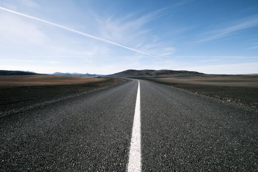 A beautiful view of an empty asphalt road under blue cloudy sky