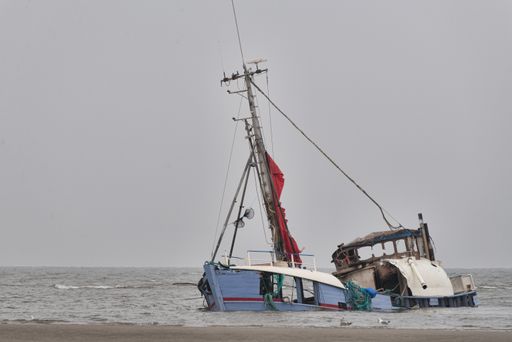 A sinking abandoned ship at the seashore under the clear sky