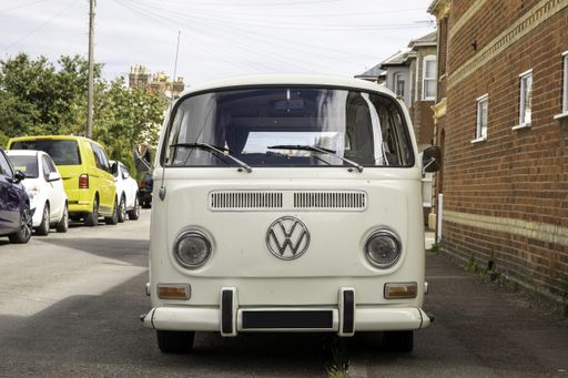 A front view of a parked white VW camper va