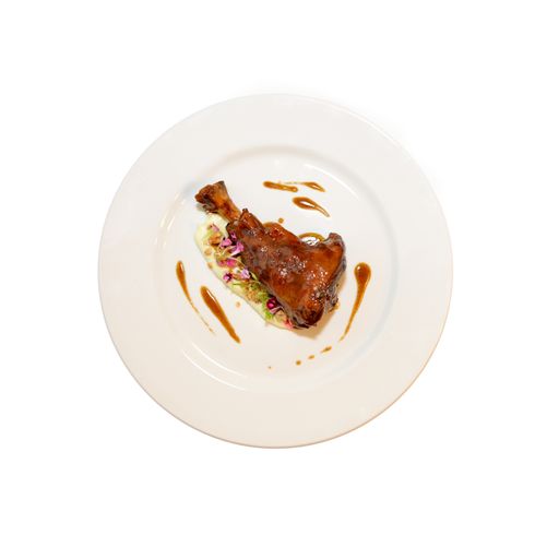 A top view shot of duck confit with mash and flower salad