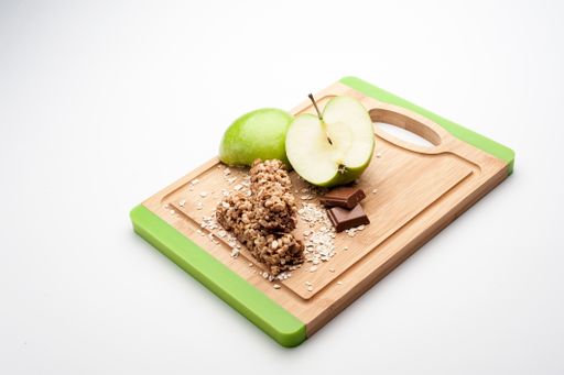 The sliced green apples with candies on the wooden board