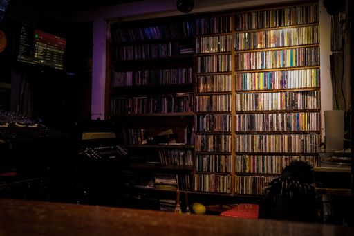 An interior of vinyl shelves in a nightclub in dim lighting