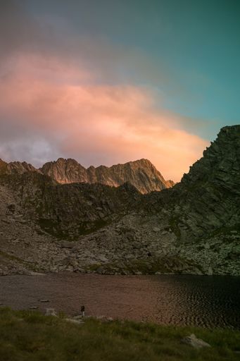 A vertical shot of mountains and fog during the sunset