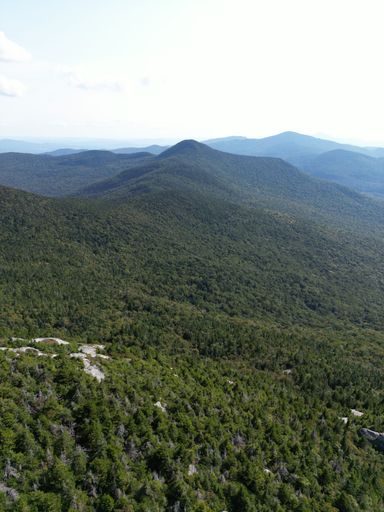 A drone shot of the range of Green Mountains on a sunny day in the U.S. state of Vermont