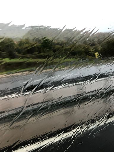 A vertical shot of rain droplets on the window