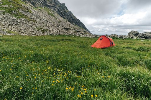 A closeup shot of a red hiking tent in the mountains - perfect for an article about hiking