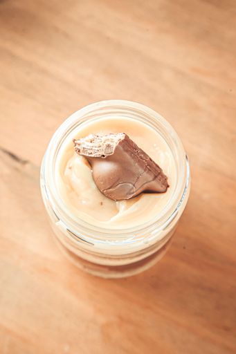 A top view of melted candy, white chocolate in a bar with a chunk of candy in it