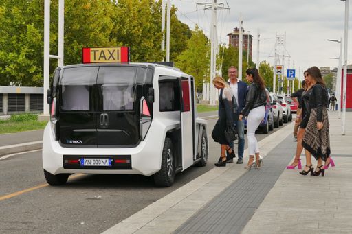 The view of people getting into a white ETIOCA full electric minivan taxi
