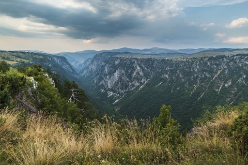 A beautiful shot of a canyon in the mountains and the cloudy sky in the background